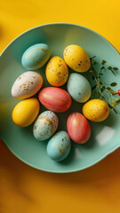 Colorful Easter eggs in a bowl against a vibrant yellow backdrop. Top view. Vertical format. Ideal for seasonal marketing, holiday Easter recipes, or creative craft inspiration.