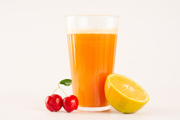 Fresh Organic Acerola and Orange Juice with sliced acerola and orange fruit in a glass cup in white background in top view