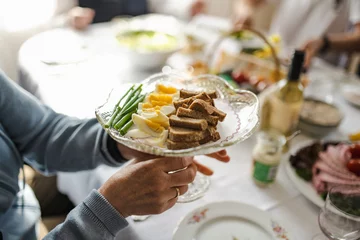 Fotobehang Traditional Easter breakfast food in Lithuania. Lithuanians also include a variety of cold dishes, freshly baked bread, boiled painted eggs, hams, sausages, fresh vegetables. © MNStudio