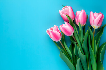 Top view of spring tulip flowers arranged on a blue background in flat lay style, creating a vibrant and festive greeting for Women's Day, Mother's Day, or a Spring Sale banner.