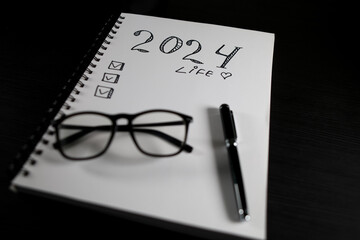 New year resolutions 2024 on desk. 2024 resolutions list with notebook, Goals, resolutions, plan, action, checklist concept. New Year