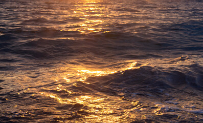Sea waves at golden hour. Beautiful sunset. LIght reflects on the water.