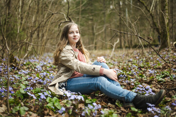 Adorable young girl hiking in the woods on beautiful spring day. Teenager portrait in spring park.