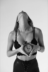 Beautiful boudoir model holding vintage clock in her hands