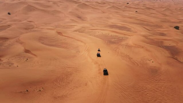 Dune buggy tour in Dubai desert dunes UAE, aerial birds eye drone view