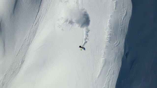 Drone view of a skier descending a steep slope. Freeride