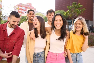 Fotobehang Generation z people walk carefree and cheerful. Group smiling multiracial friends having fun outdoors. Joyful young student laughing together on vacation. Community, youth lifestyle and friendship © CarlosBarquero
