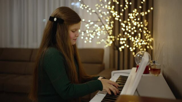 A teenage girl plays the piano