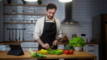 Fototapeta premium Vlogger professional man chef in an apron recording video cooking lesson about vegetarian meal in modern kitchen 