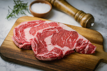 raw ribeye steak beef on white marble background - obrazy, fototapety, plakaty