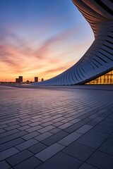 Modern architecture of a building with a curved roof at sunset
