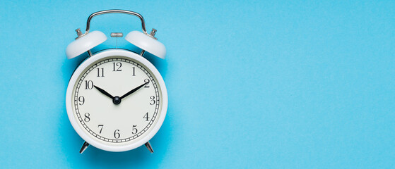 Classic Analog Alarm Clock on Blue Background, Time and Change Concept, Copy Space