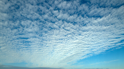 Sun shining through the puffy clouds. Sky view. Beautiful sunny sky. Background with clouds on blue sky. Clouds on blue sky.