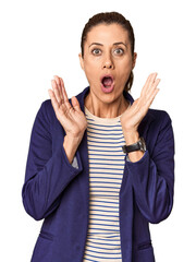 Middle-aged female entrepreneur in studio surprised and shocked.