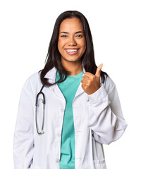 Young Filipina doctor with stethoscope in studio smiling and raising thumb up