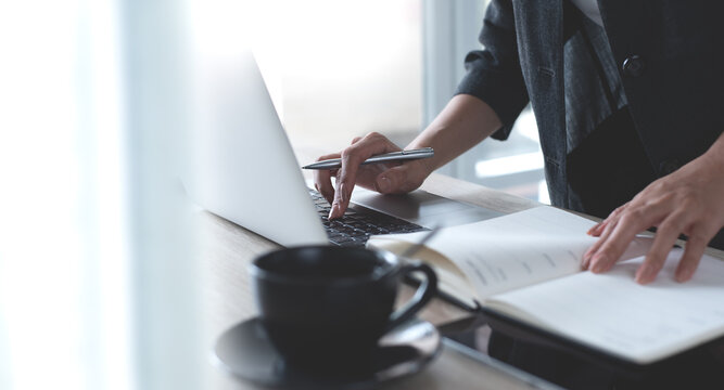 Businesswoman working on laptop computer, planning the event on calendar planner at modern office. Business woman, entrepreneur surfing the internet, online working at home office, closeup