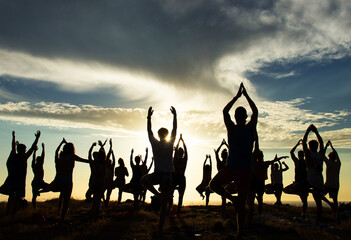 Silhouette of an outdoor yoga class at sunset