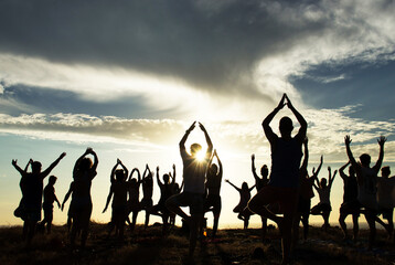 Silhouette of an outdoor yoga class at sunset 