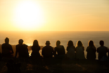 Group of people watching a sunset from a mountain 