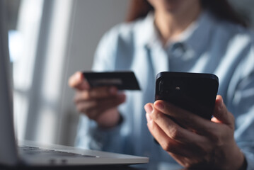 Young woman using mobile smart phone and credit card for digital banking via mobile banking app, internet payment and online shopping, financial technology, global business, e-transaction