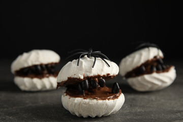 Delicious desserts decorated as monsters on grey table. Halloween treat