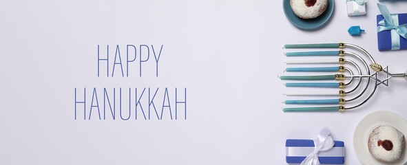 Happy Hanukkah. Menorah, donuts, dreidel and gifts on light background, flat lay. Banner design