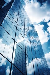 Fototapeta premium Blue glass skyscraper reflecting clouds