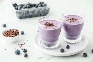 Freshly made blueberry smoothies topped with cacao nibs.