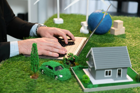 Businessman planning on his laptop for implementation of clean and sustainable energy to reduce CO2 emission in eco green company with for greener sustainable Earth. Quaint