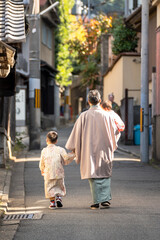 Parent and child wearing Japanese traditional Kimono walking on the street. Kyoto, Japan.