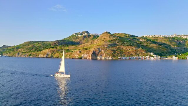 White yacht sailing by greek island coast. Milos Cyclades Creece