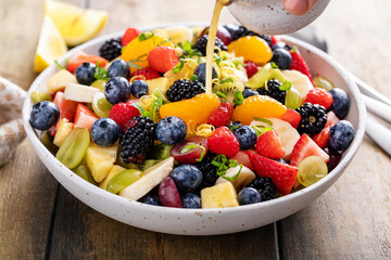 Healthy and colorful fruit salad with orange dressing and fresh mint