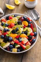 Healthy and colorful fruit salad with orange dressing and fresh mint