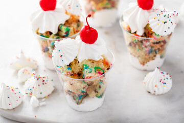 Funfetti cake in a cup with whipped cream and cherry on top