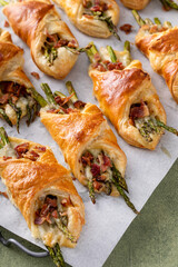 Asparagus appetizers wrapped in puff pastry with melted cheese