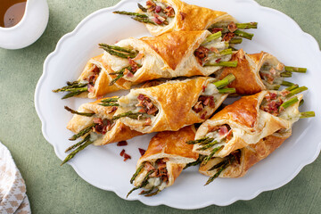 Asparagus appetizers wrapped in puff pastry with melted cheese - obrazy, fototapety, plakaty