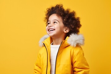 Portrait of cheerful happy boy / girl wearing headphones listen to music dance isolated on yellow...