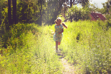 Naklejka premium Teenager girl in the meadow with raised hands, rear view. Running, dancing and enjoy. Summer sunset. Enjoying Life