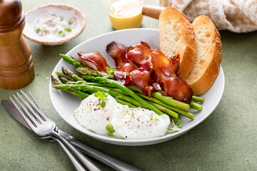 Healthy and filling breakfast bowl with poached eggs, bacon, asparagus