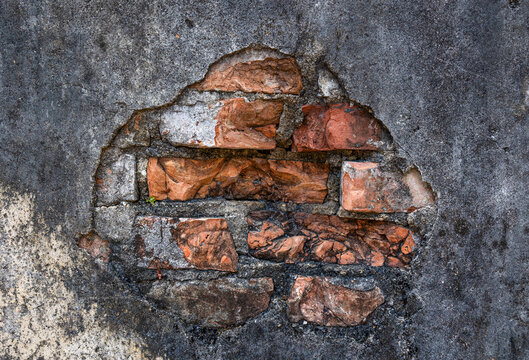 aged gray wall with brick hole in the middle background texture