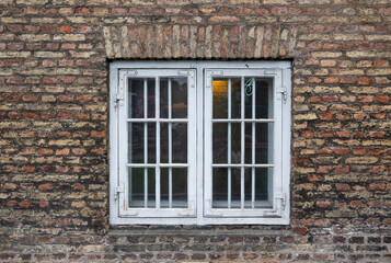 Fototapeta na wymiar European vintage white old window in the old brick wall exterior background