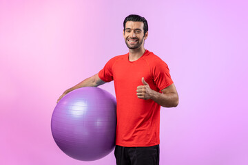 Full body length gaiety shot athletic and sporty young man with fitness exercising ball in standing...
