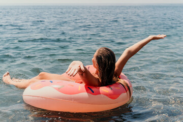 Summer Vacation Woman floats on an inflatable donut mattress, a water toy swim ring. Positive happy woman relaxing and enjoying family summer travel holidays vacation on the sea. Slow motion