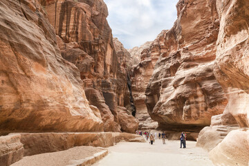 Numerous tourists walk at beginning of route and sightseeing at Al Siq in Petra in Wadi Musa city...
