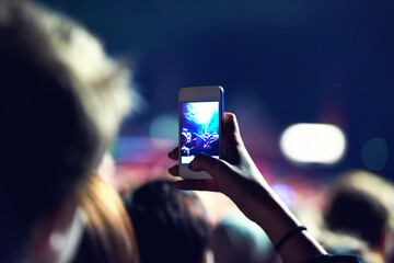Woman, hand and smartphone for picture at concert with post, social media or recording of show....