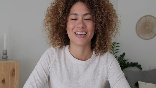 Screen view of young multiracial woman on online meeting talking and taking notes looking at camera. 4k resolution video