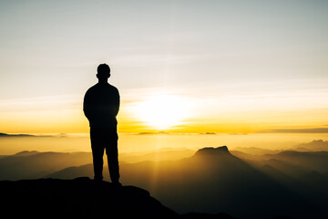 Solitary figure gazing at mountain sunset