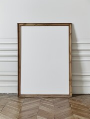 large blank wooden picture frame leaning against a white wall - poster/art design mockup template