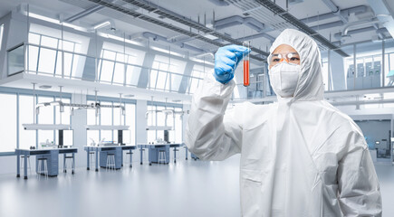 Worker or scientist wears medical protective suit or white coverall suit hold test tube