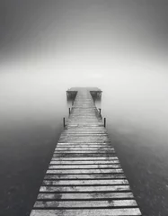Poster Minimalist artistic image of a wooden jetty disappearing into the fog in black and white. © Inge